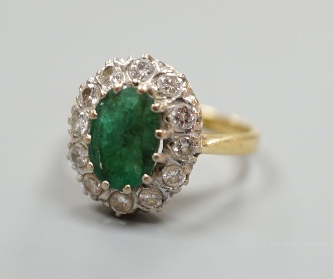 A yellow metal, emerald and diamond set oval cluster ring, size P/Q, gross weight 5 grams.
